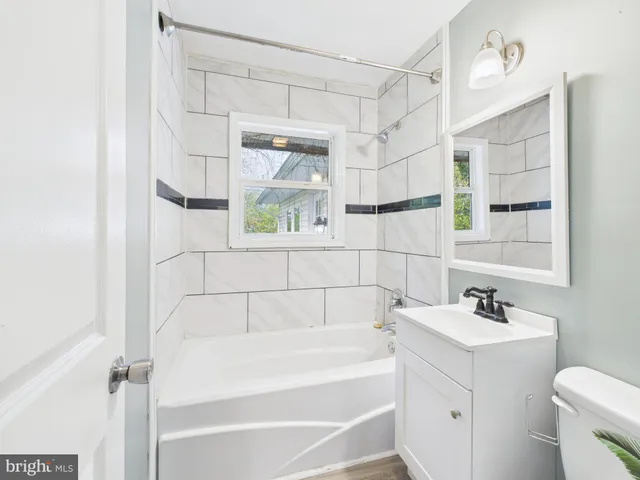 a bathroom with a bathtub a sink a vanity and a window