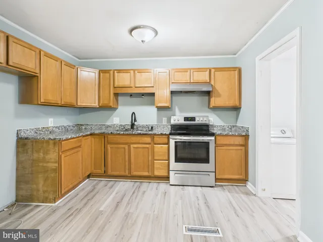 a kitchen with granite countertop wooden floors and stainless steel appliances