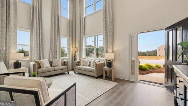 a view of a dining room with furniture large windows and wooden floor