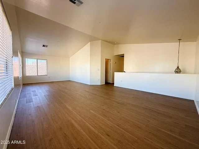 a view of empty room with wooden floor