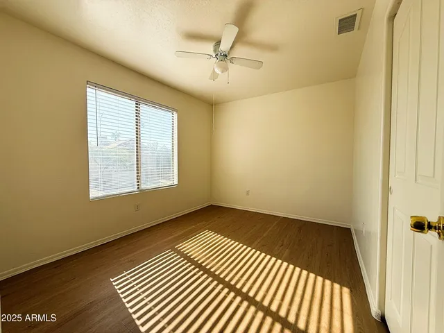 a view of an empty room with a window and a wooden floor