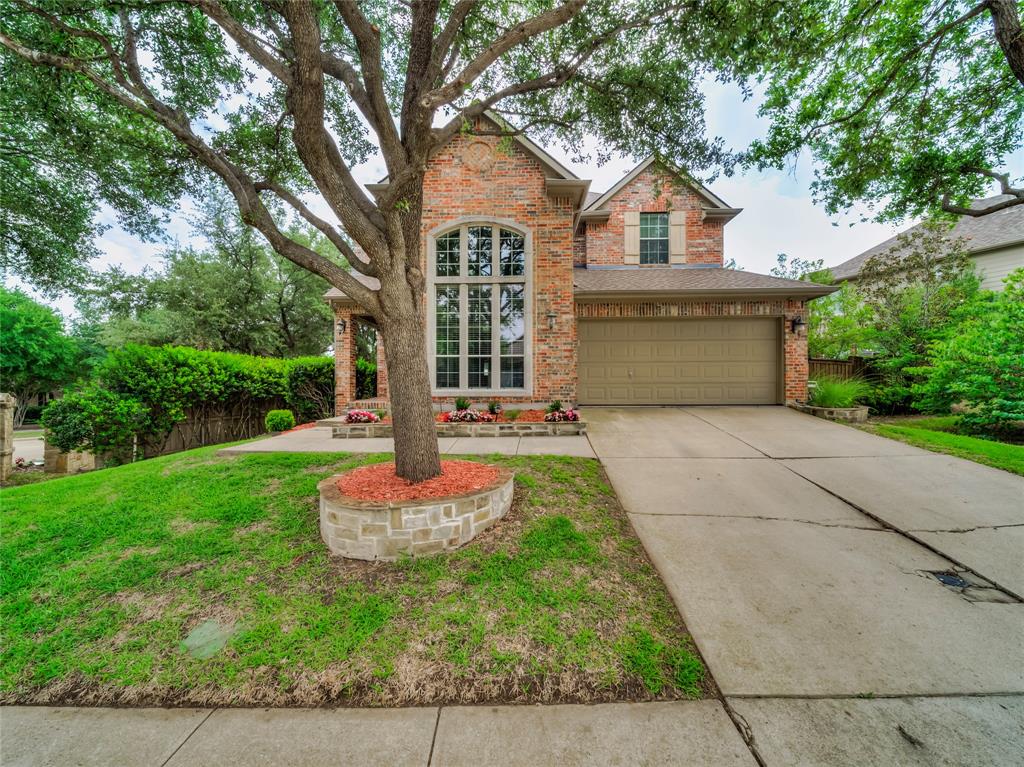 a front view of a house with a yard and trees