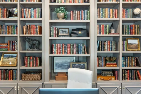 a living room with bookshelf lots of books and a book shelf