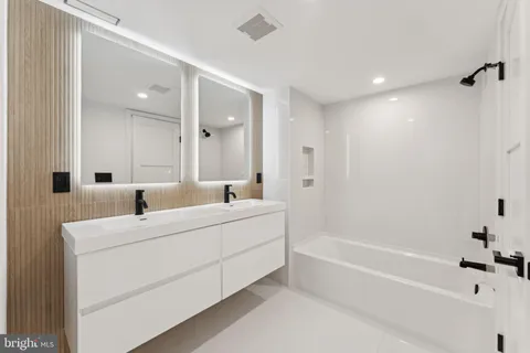 a bathroom with a tub shower and sink