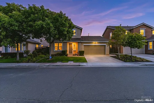 a front view of a house with a yard and a garage