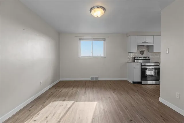 a view of a kitchen with a sink wooden floor and a window