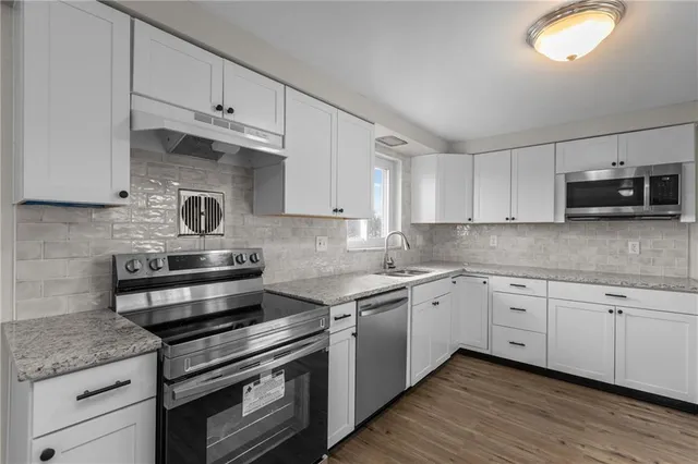 a kitchen with granite countertop cabinets stainless steel appliances and a sink