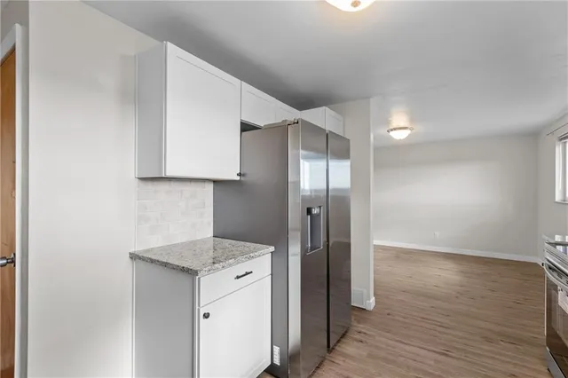 a view of a refrigerator in kitchen and wooden floor