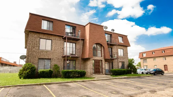 a front view of a residential apartment building with a yard