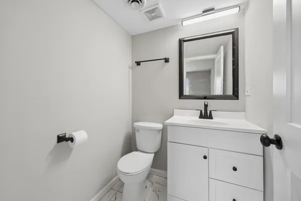 a bathroom with a toilet sink and mirror