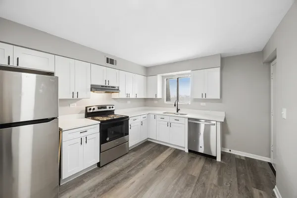 a kitchen with granite countertop a refrigerator stove top oven and sink