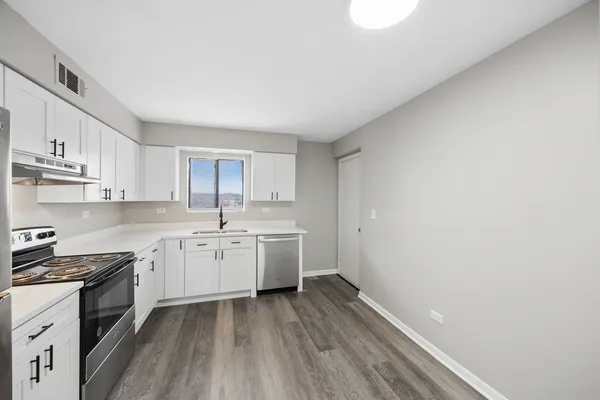 a kitchen with cabinets wooden floor and a sink
