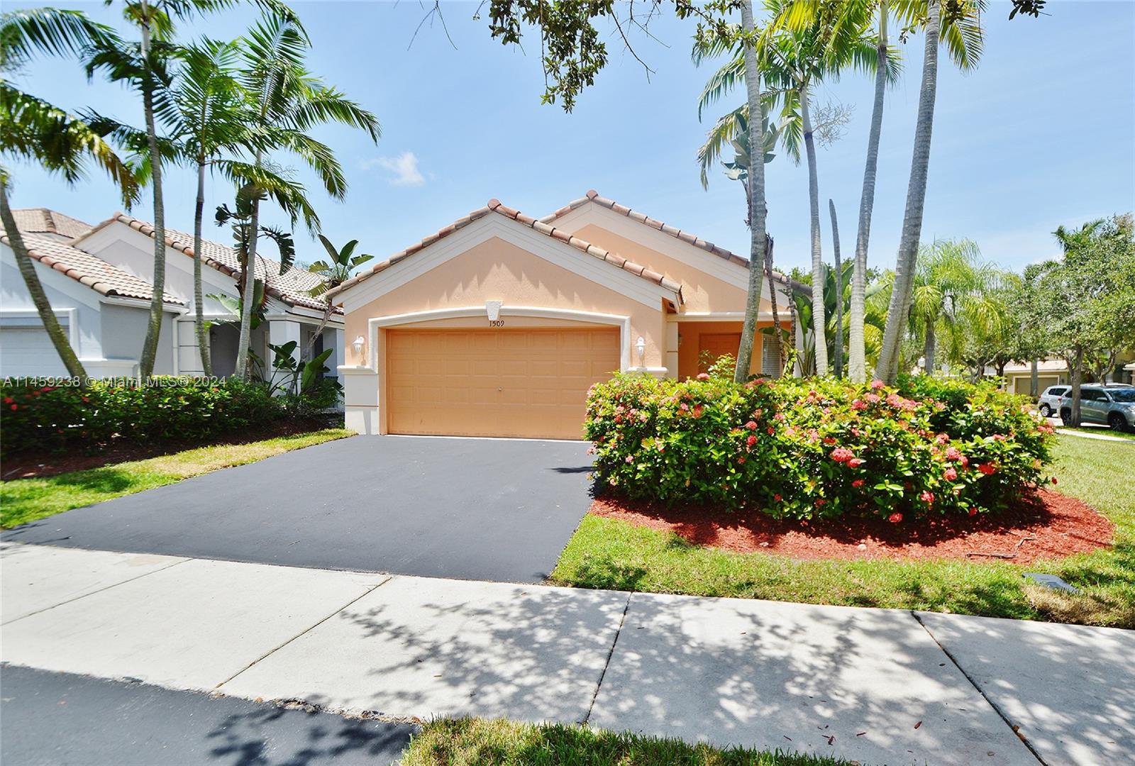 1509 Sunset Way Weston, FL 33327 - Photo 1 of 24 a front view of a house with a garden