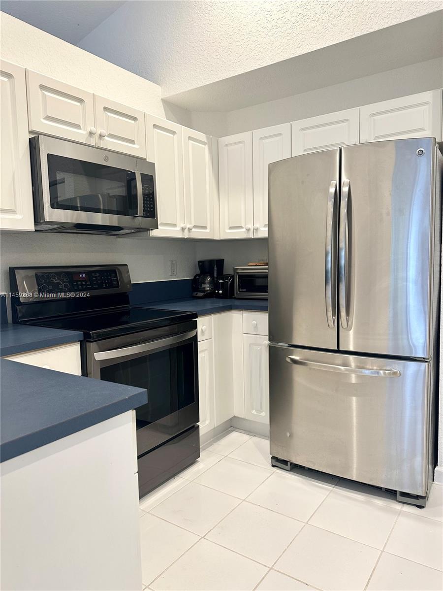1509 Sunset Way Weston, FL 33327 - Photo 11 of 24 a white refrigerator freezer and a stove in a kitchen