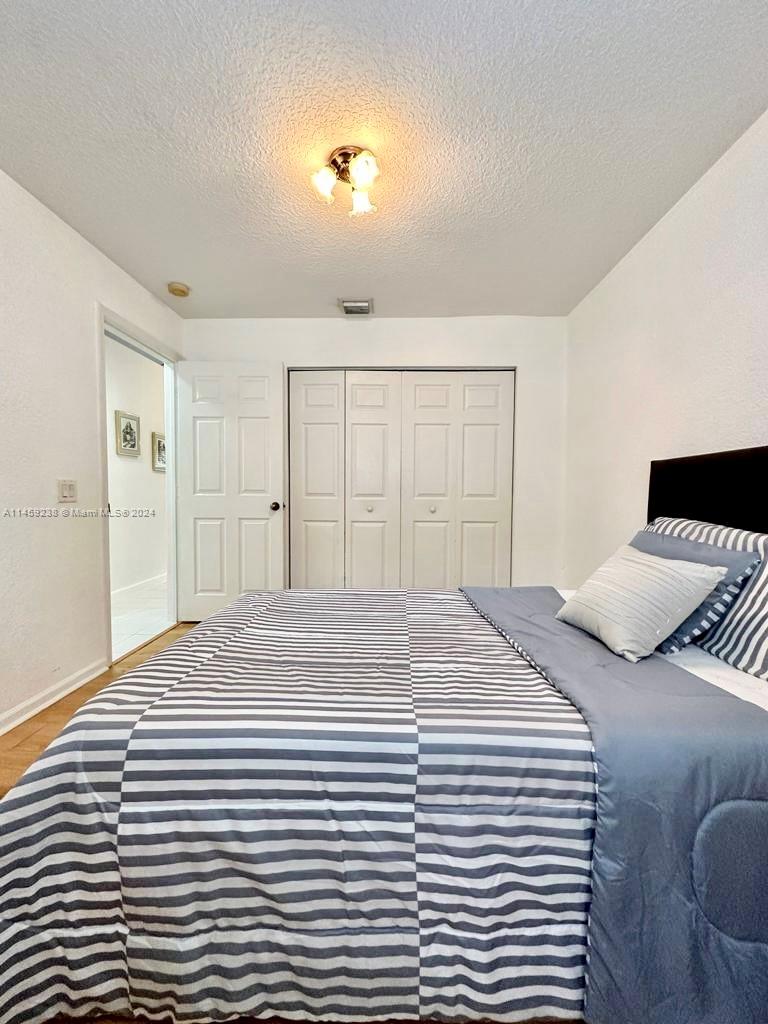 1509 Sunset Way Weston, FL 33327 - Photo 18 of 24 a bedroom with a bed and a chandelier