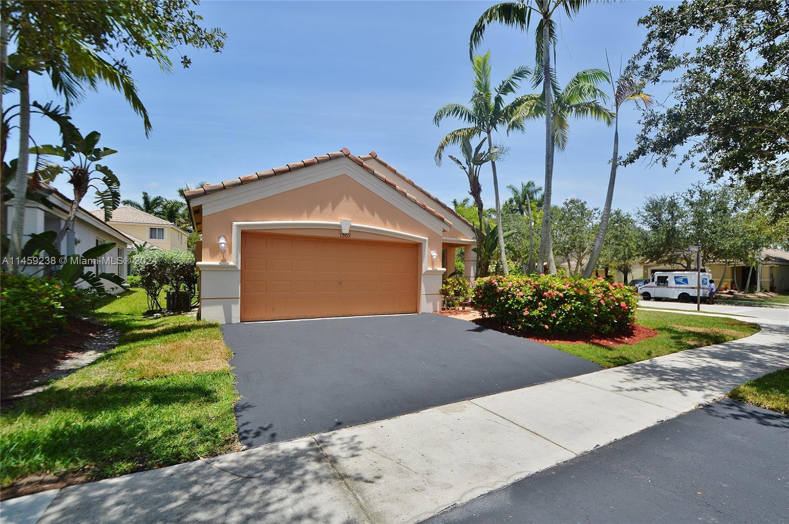 1509 Sunset Way Weston, FL 33327 - Photo 2 of 24 a front view of a house with garden