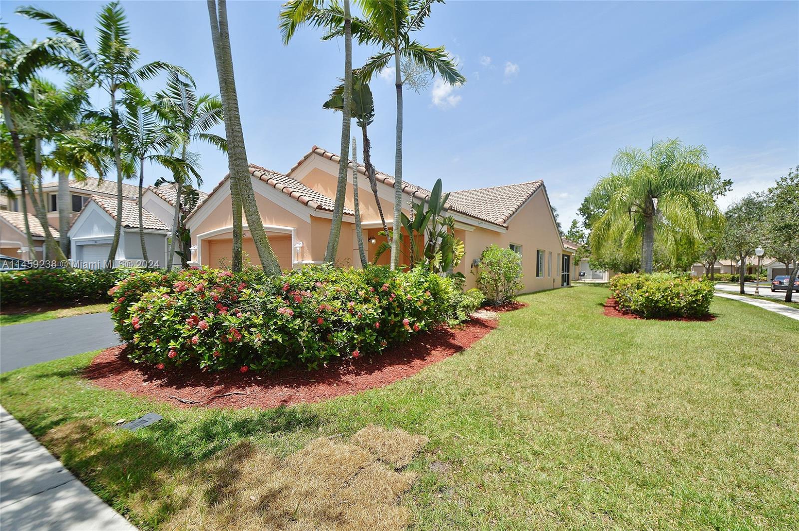 1509 Sunset Way Weston, FL 33327 - Photo 3 of 24 a front view of a house with a yard and fountain