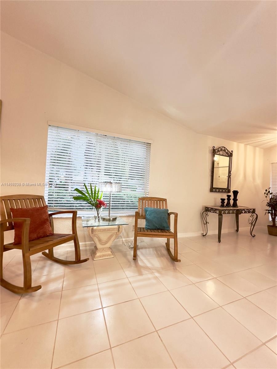 1509 Sunset Way Weston, FL 33327 - Photo 5 of 24 a living room with patio furniture and a dining table with kitchen view
