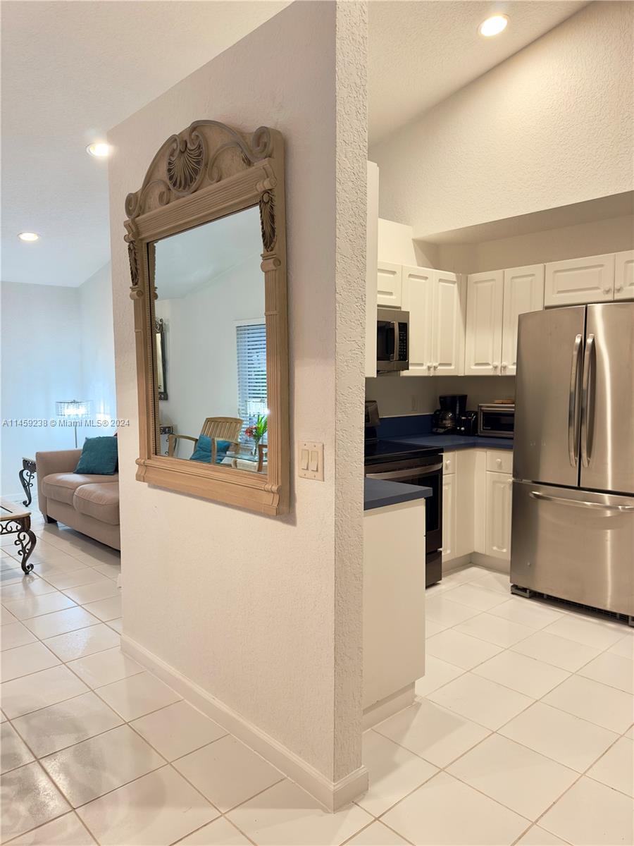 1509 Sunset Way Weston, FL 33327 - Photo 10 of 24 a kitchen with stainless steel appliances a refrigerator and a stove top oven
