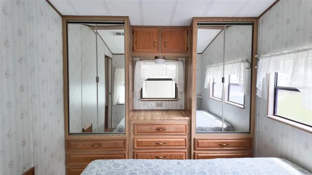 a bedroom with a bed and a dresser next to a window