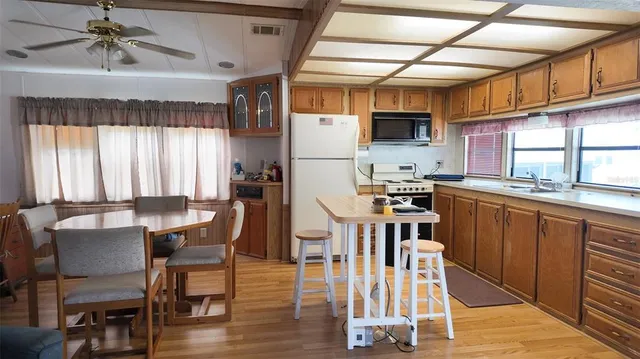 a kitchen with stainless steel appliances wooden floors stove top oven and cabinets