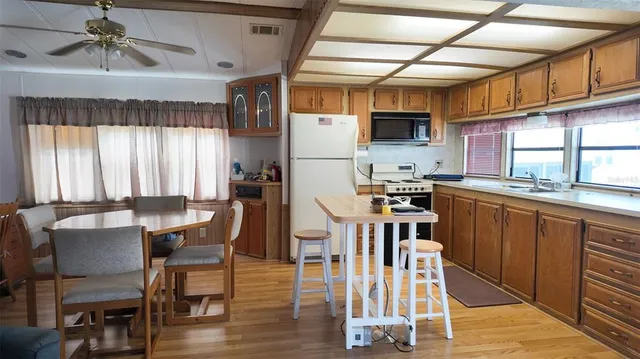 a kitchen with stainless steel appliances wooden floors and wooden cabinets