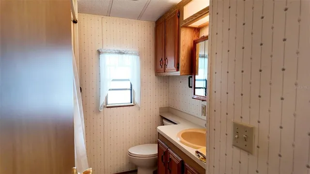 a bathroom with a toilet sink and mirror