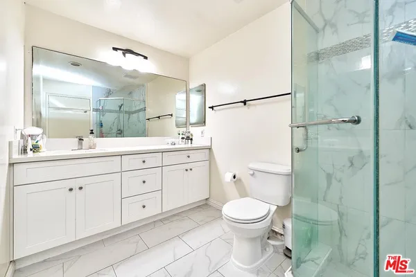 a bathroom with a double vanity sink toilet and shower