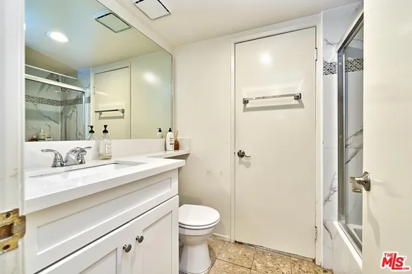 a bathroom with a sink a toilet a shower and a mirror