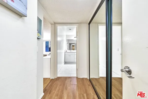 a view of a hallway with wooden floor and a living room