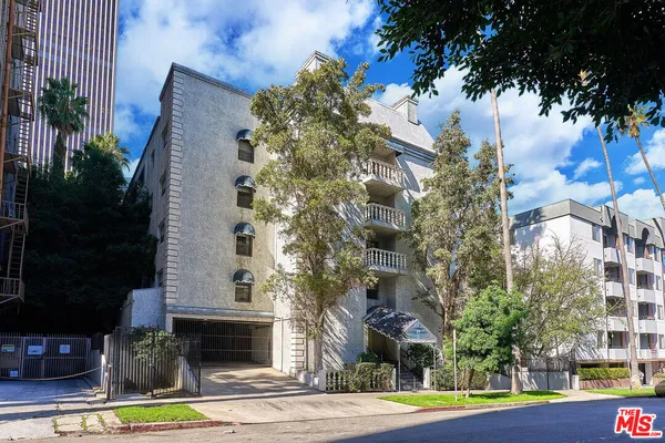 a view of a tall building in the middle of a yard