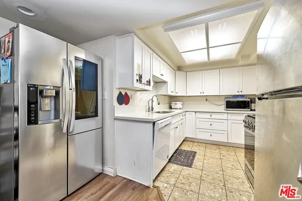 a kitchen with stainless steel appliances a refrigerator sink and cabinets