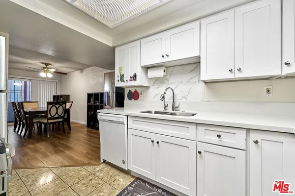 a kitchen with white cabinets and sink