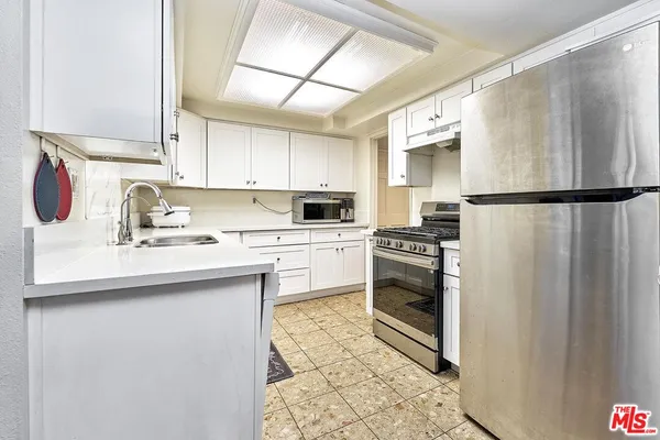 a kitchen with a sink a refrigerator a washer and dryer