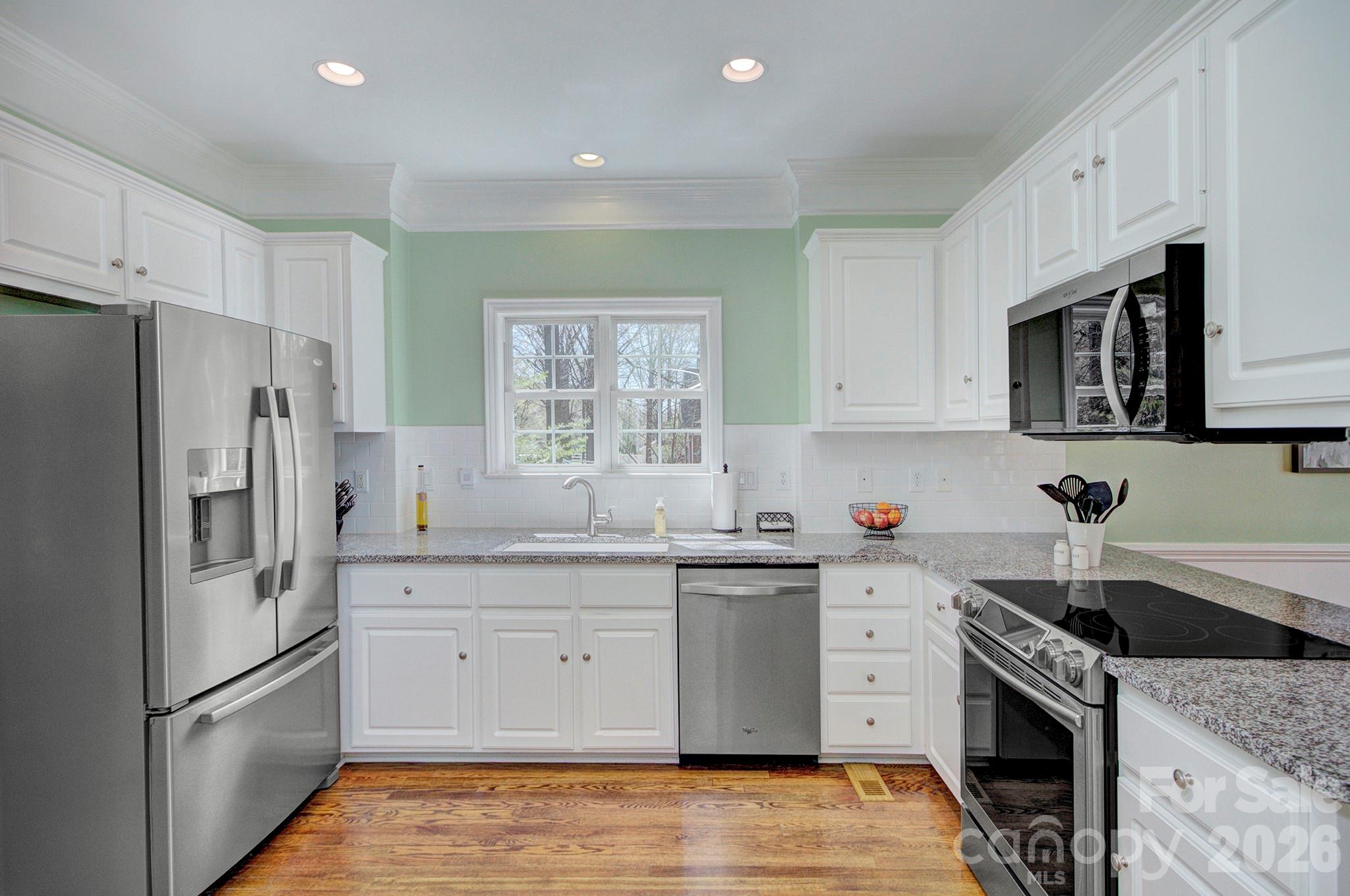 4839 Antioch Church Road Matthews, NC 28104 - Photo 16 of 36 a kitchen with stainless steel appliances granite countertop a refrigerator sink stove microwave and cabinets