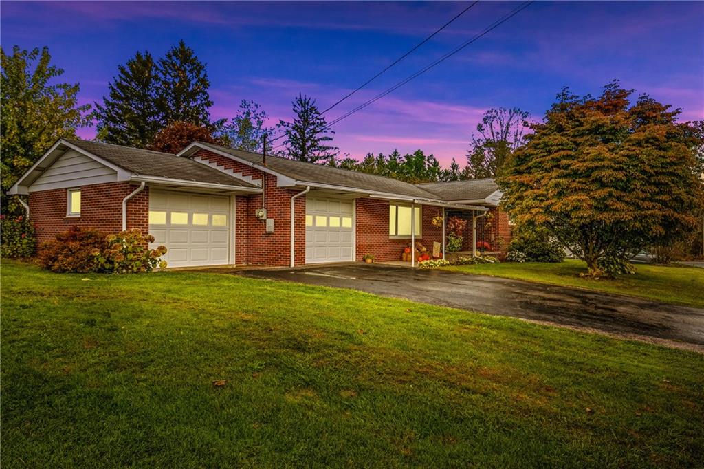 a front view of a house with a garden and yard