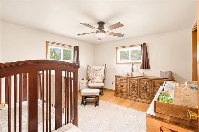 a view of a bedroom with furniture window and a ceiling fan