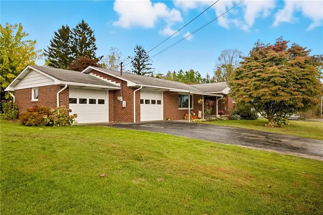 a view of a house with a big yard and large trees