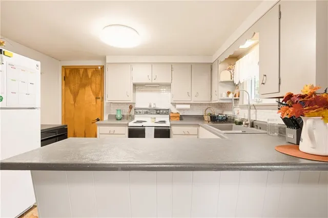 a kitchen with kitchen island granite countertop a sink cabinets and window