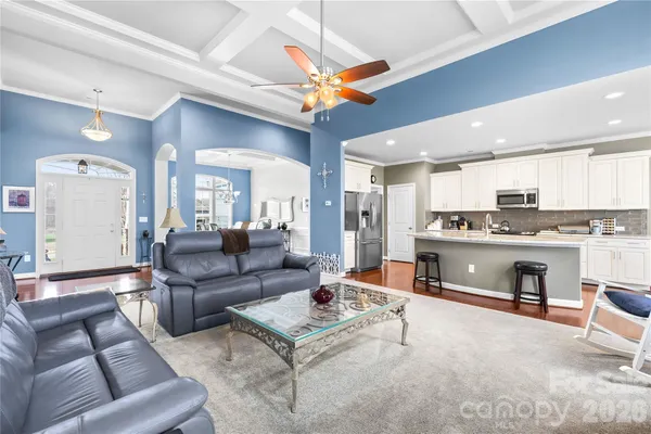 a living room with furniture a flat screen tv and a large window