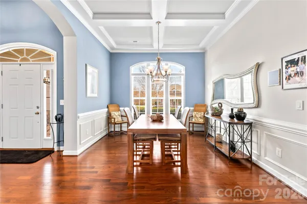 a kitchen with stainless steel appliances granite countertop a table chairs refrigerator sink and microwave