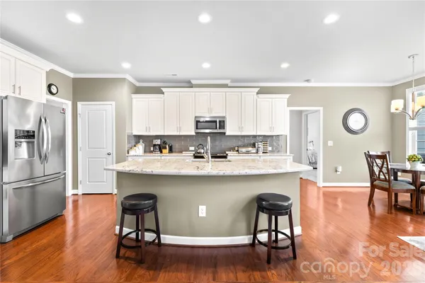 a kitchen with stainless steel appliances granite countertop a stove a sink a microwave a center island and furniture