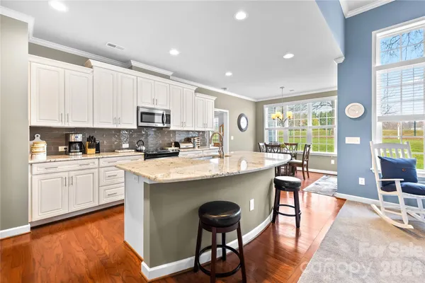 a living room with stainless steel appliances kitchen island granite countertop furniture and a large window