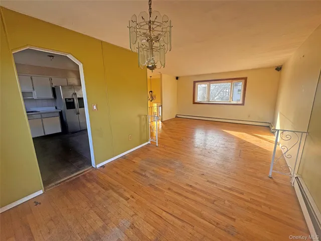 a view of a hallway with wooden floor and a living room