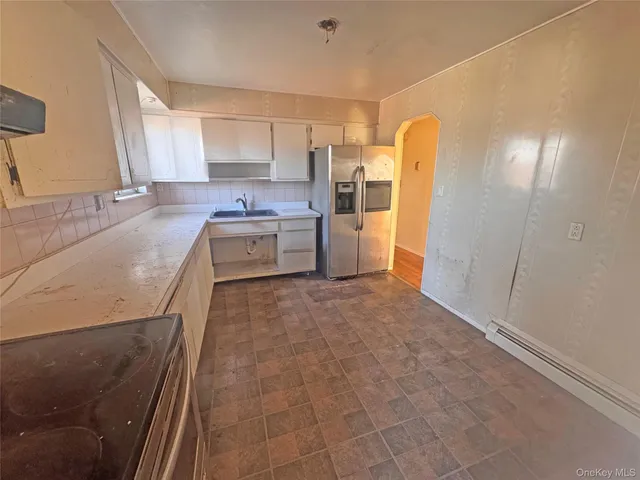a large kitchen with a sink and stainless steel appliances