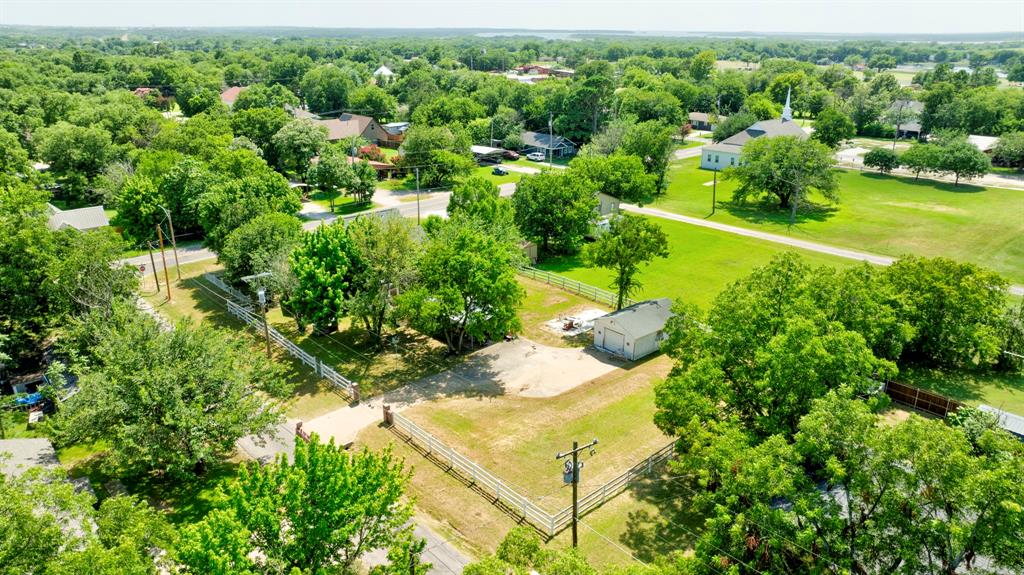 503 Sherman Street Tioga, TX 76271 - Photo 10 of 13 Expansive lot featuring a detached two-car garage, white picket fencing, and mature trees