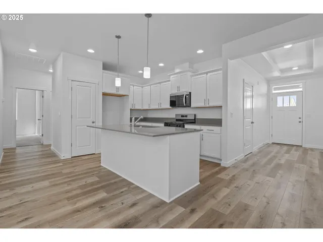 a kitchen with kitchen island a sink stainless steel appliances and cabinets