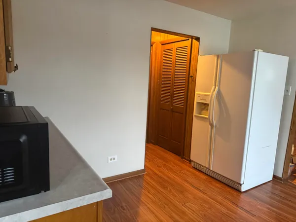 a view of a kitchen with wooden floor and a cabinet