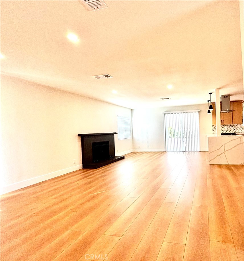 6210 Halstead Avenue, Unit A Rancho Cucamonga, CA 91701 - Photo 26 of 32 a view of empty room with wooden floor and fireplace