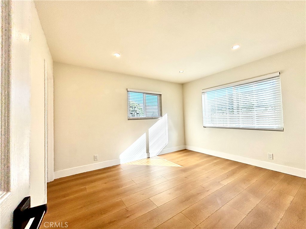 6210 Halstead Avenue, Unit A Rancho Cucamonga, CA 91701 - Photo 30 of 32 a view of an empty room with wooden floor and a window